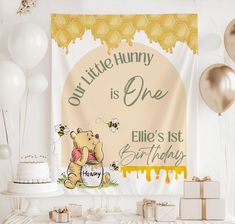 a winnie the pooh birthday banner hanging on a wall next to balloons and cake