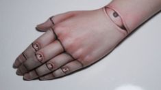 a woman's hand with an eyeball tattoo on her left wrist and fingers