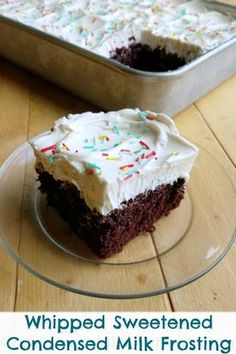 a piece of cake with white frosting and sprinkles sitting on a glass plate