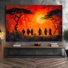 a painting on the wall of a living room with two people walking in front of an orange sunset