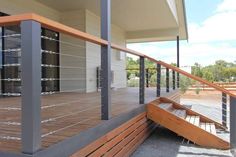 a wooden deck with metal railing and handrails