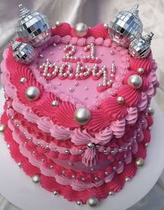 a birthday cake with pink frosting and silver decorations