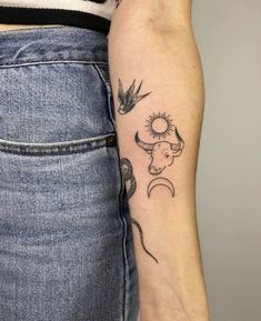 a woman's arm with tattoos on it and birds flying over the moon in the sky