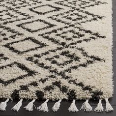 a black and white rug with tassels on it