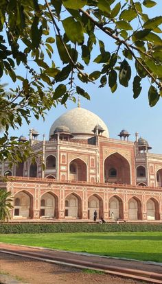 a large building with a dome on top in the middle of a green lawn area