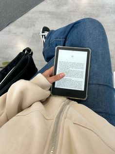 a person laying on the floor with their legs crossed and holding an electronic device in their lap