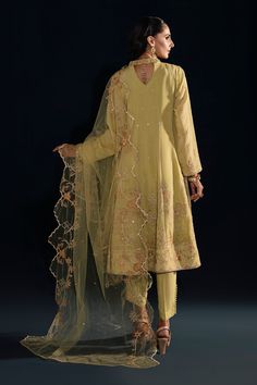 Lemon Green Embroidered Pakistani Party Wear Frock Trousers Dupatta is skillfully crafted pear green kalidar frock is adorned with machine embroidery, hand embellishments, minimal lace details & machine embroidered panels with motif spread on the neckline, front, back & sleeves. Outfit is paired with button detailed straight pants & machine embroidered dupatta with two sided scalloped borders. Frock: An enchanting frock in blush color tailored on a black canvas with heavily embroidered borders w