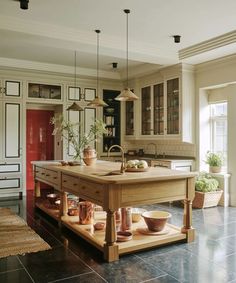 a large kitchen island in the middle of a room with pots and bowls on it