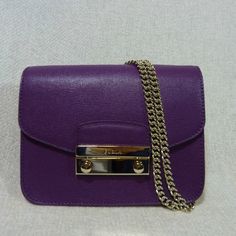 Baby Julia Shoulder Bag By Furla. This Shoulder Bag Is Made Of Adorable Eggplant Purple Saffiano Leather. Gold Tone Hardware Dimensions: 6.5" Widest X 4.5" Tall X 2 2/3" Deep. Comes With 50" Long Chain Shoulder Strap. Can Be Carried As Cross Body Bag, Doubled The Chain Strap And Carry Is As Shoulder Bag Or Carry It As A Clutch Flap And Lock Closure. These Are The Newer Version Of Baby Julias So They No Longer Come With Key Bells And Keys. Fabric Interior Lining With 3 Card Slots. It's In Solid P Designer Purple Bag With Gold-tone Hardware, Designer Purple Bags With Gold-tone Hardware, Luxury Purple Shoulder Bag With Detachable Strap, Luxury Purple Shoulder Bag With Gold-tone Hardware, Luxury Purple Evening Bags, Luxury Purple Bag With Branded Hardware, Luxury Purple Shoulder Bag For Formal Occasions, Luxury Purple Formal Shoulder Bag, Purple Leather Shoulder Bag With Chain Strap