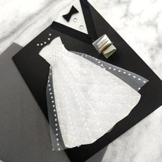 a black and white wedding card with a dress on it's lapel cover