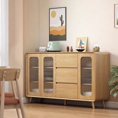 a wooden cabinet with glass doors in a living room next to a table and chair