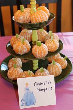 three tiered trays filled with oranges on top of a pink table cloth