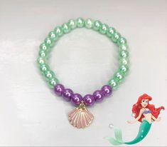 the little mermaid bracelet is decorated with pearls