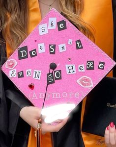 a woman wearing a pink graduation cap with words written on it and she doesn't even be there