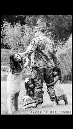 an old black and white photo of two soldiers with their children on the grass in front of some trees