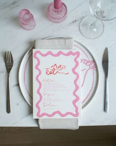 a place setting with pink napkins and silverware on a white marble table top