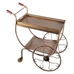 a metal and glass serving cart with wheels