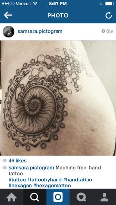 the back of a woman's stomach with an intricate tattoo design on her side