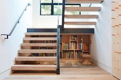 the stairs are made of wood and have bookshelves on each side, along with a bookcase full of books