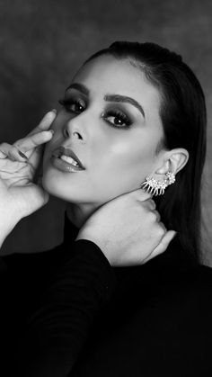 black and white photo of a woman wearing earrings