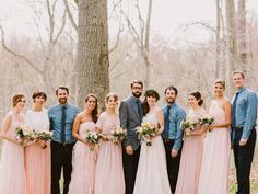 a group of people standing next to each other in front of a tree with flowers