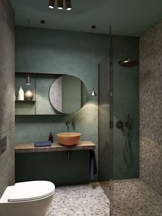 a bathroom with a toilet, sink and mirror in it's corner area next to a walk - in shower