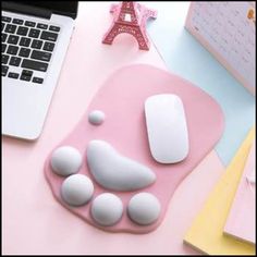 a pink mouse pad sitting on top of a desk next to a white laptop computer