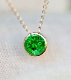 Genuine earth mined AA tsavorite garnet set in solid 14k gold in a slide pendant. The pendant moves on the chain. A simple classic style that you can never go wrong with.  Stone Size : 4mm Necklace Length : see options Metal : 14k Gold Gemstone : 0.3 cts (4mm stone)  Earth Mined AA Tsavorite Garnet or 0.6 cts (5mm stone) Packaging : All products purchased from us come in a gift box. If you need to include a message, kindly leave us a note when purchasing.  Care Recommendations:  When not in use, Green Gemstone Birthstone Necklace In 14k Gold, Tsavorite Emerald Necklace In Yellow Gold, Yellow Gold Emerald Necklace With Tsavorite, Formal Green Birthstone Necklace In 14k Gold, Formal Green 14k Gold Birthstone Necklace, Green Pendant Birthstone Necklace In 14k Gold, Green Birthstone Pendant Necklace In 14k Gold, Green 14k Gold Pendant Birthstone Necklace, 14k Gold Green Birthstone Pendant Necklace