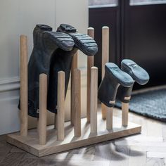 three pairs of shoes are lined up on wooden poles