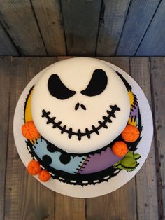 a decorated cake with white frosting and black icing on a wooden table top