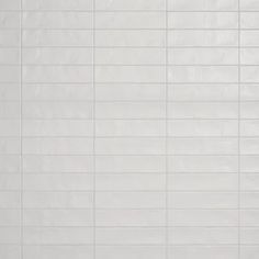 a white tiled wall and floor with no one in the room or someone standing on it