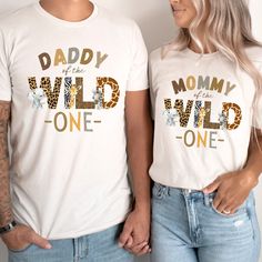 Wild One 1st Birthday Shirts, The Wild One Theme First Birthday Family Matching Shirt, Daddy Mama of the Wild One, Mommy and Me Tshirts Introducing our Wild One Birthday Shirt - the perfect outfit to celebrate your little one's 1st birthday in style! Whether you're planning a family birthday gathering or a wild adventure-themed party, our shirt is a must-have for the occasion. Designed with love and attention to detail, our Wild One Birthday Shirt is crafted from high-quality materials, ensuring comfort and durability for your little wild child. The vibrant colors and playful design capture the essence of a safari, jungle, or zoo animal birthday celebration, making it an ideal choice for any animal-loving family. This shirt is not only a celebration of your little one's milestone but also First Birthday Funny Print Crew Neck T-shirt, First Birthday Crew Neck Shirt With Graphic Print, First Birthday Graphic Print Crew Neck Shirt, First Birthday Graphic Tee With Letter Print, Mommy And Me Tshirts, Wild One Birthday Shirt, Wild One Theme, Birthday Gathering, Wild One 1st Birthday