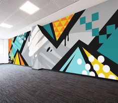 an empty room with a large colorful mural on the wall and carpeted flooring