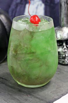 a green drink with a cherry on the top