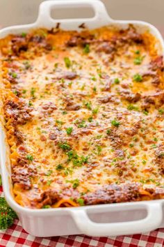 a casserole dish with meat and cheese in it on a checkered table cloth