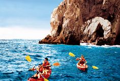 two people in kayaks paddling towards an island