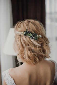 the back of a woman's head with flowers in her hair, wearing a wedding dress