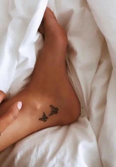 a person laying in bed with a tattoo on their left leg and the other foot