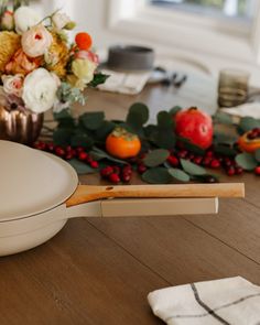 a close up of a table with flowers and other items on the table, including an egg shell