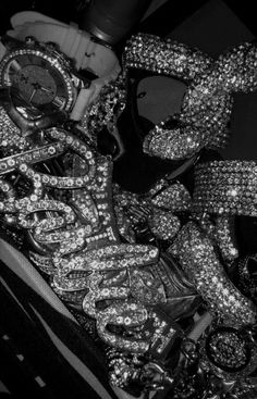 a black and white photo of someone's shoes covered in sequins with a watch on top