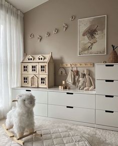 there is a white stuffed animal sitting on a wooden rocking horse in the living room