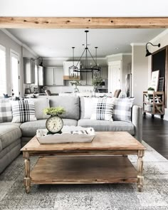 a living room filled with furniture next to a kitchen