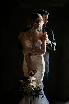 a bride and groom embracing in the dark