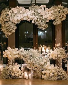 a table topped with lots of white flowers and candles