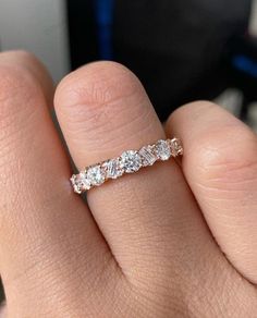 a woman's hand with a wedding band on it, and the ring has three stones