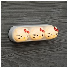 three hello kitty night lights on a wooden surface