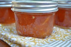 three jars filled with jam sitting on top of a table