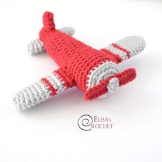 a crocheted red and white toy airplane on a white background with the words eleva crochet written below it