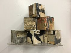 several pieces of art are stacked on top of each other in the shape of cubes