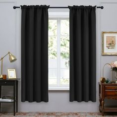 a living room with black curtains and a rug